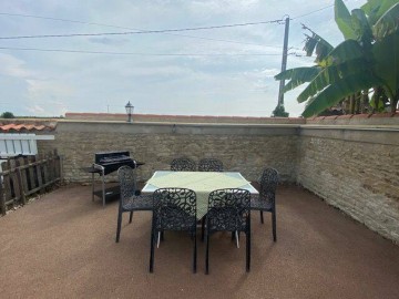 Coin repas extérieur avec barbecue, plancha et parasol._24 Gîtes de France Vendée